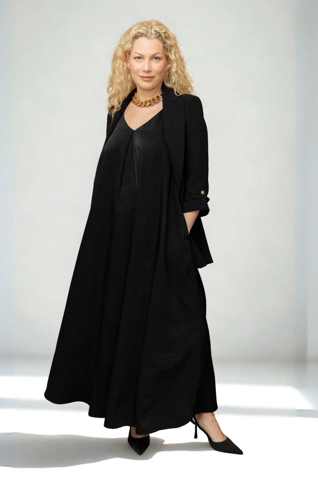 Pregnant woman in a high-end black maternity dress - premium quality luxury womenswear brand for smart office style and maternity occasion wear for events