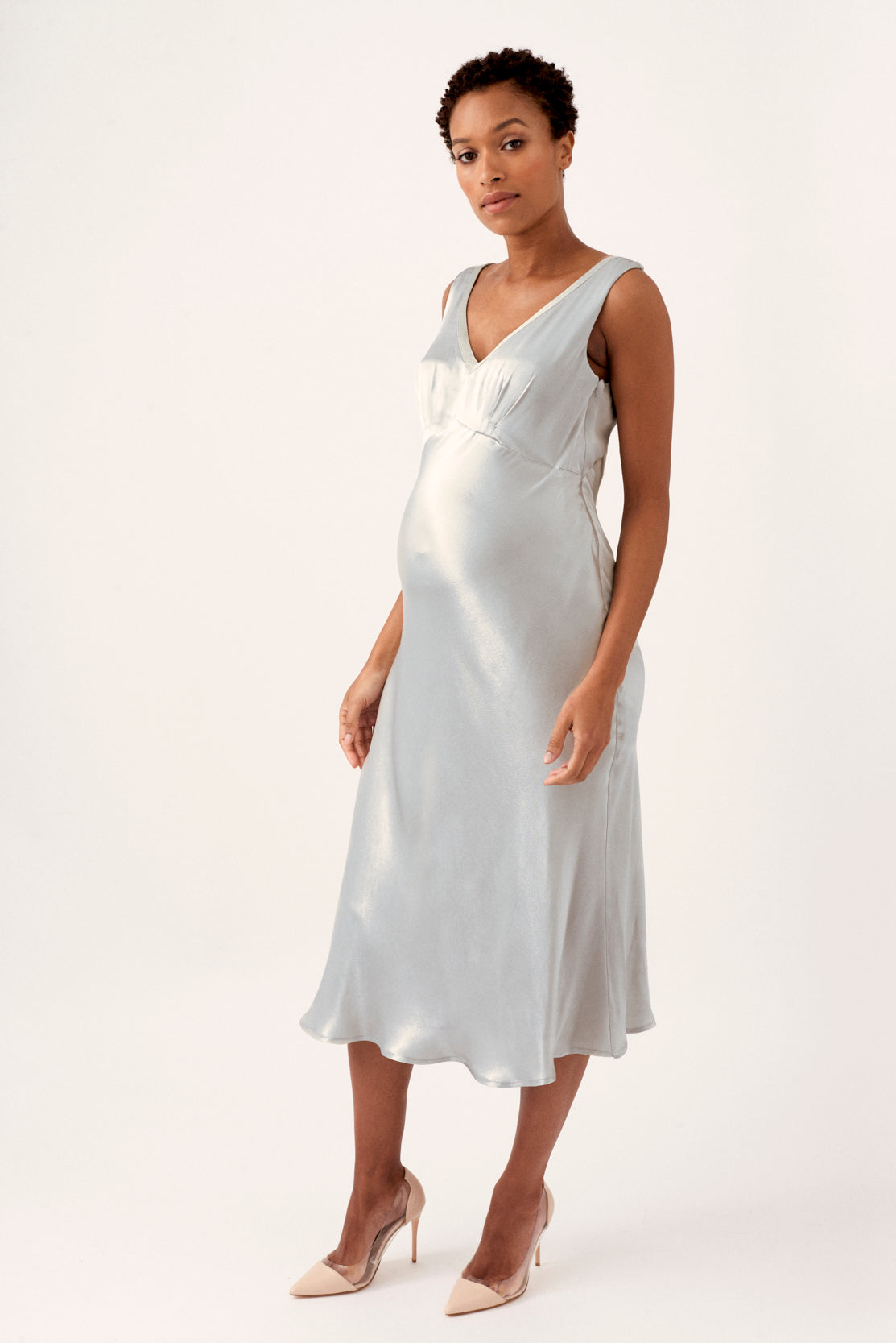 Occasion maternity dress. Make a fashion statement in this stunning silver satin dress. The perfect elevated maternity occasion wear dress for weddings, parties and evening events. The maternity dress’s clever design accommodates a 9-month bump, but is also a very flattering post-pregnancy as it drapes over the body.