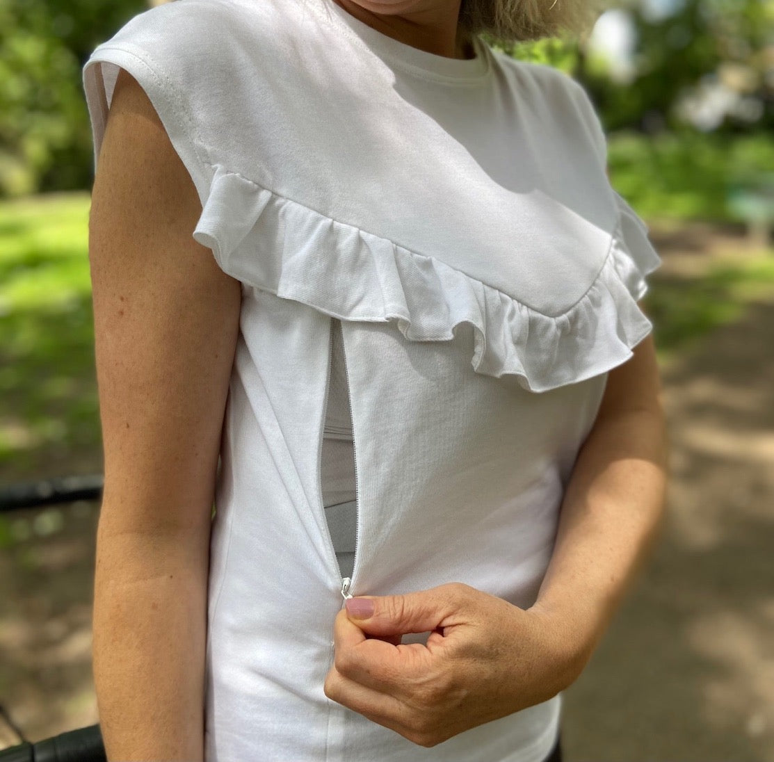 Breastfeeding top. Effortless everyday style and comfort with this white breastfeeding t-shirt. Designed for stress-free nursing on-the-go. Hidden zips sit under the ruffle, easily done one-handed makes it the perfect everyday top for new mums, and a must-have for your breastfeeding wardrobe.
