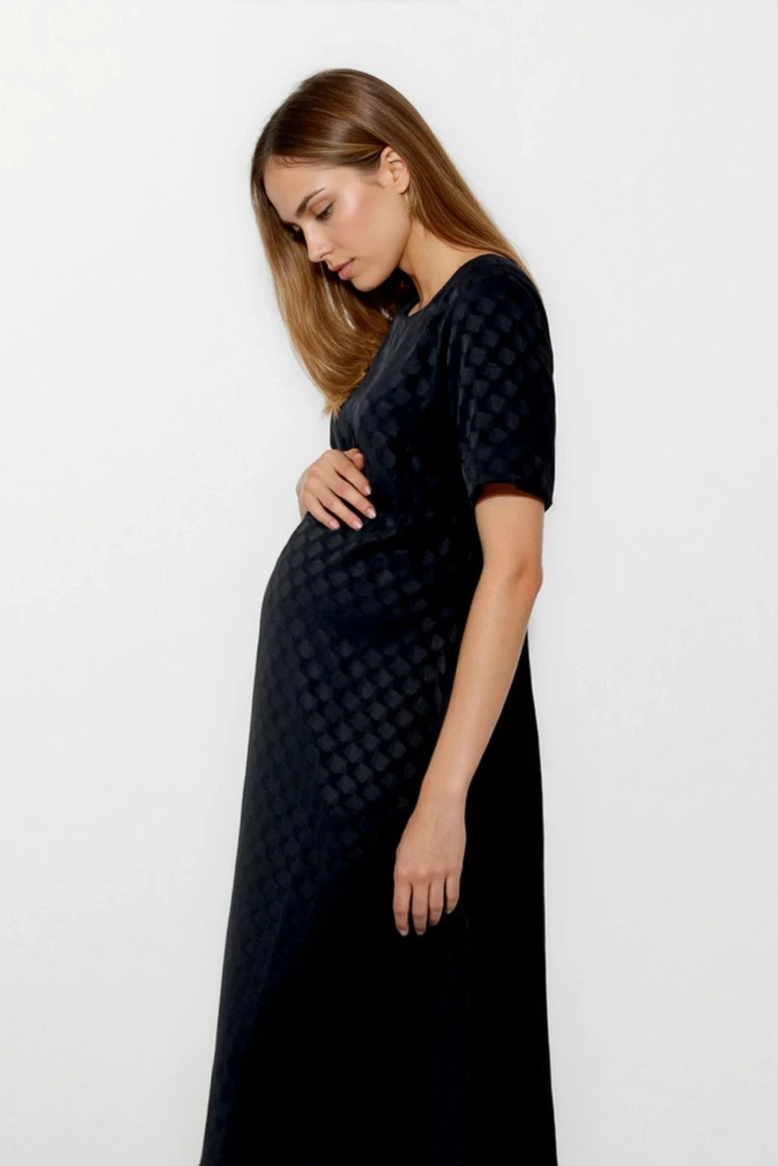 Pregnant marketing professional in smart a-line trapeze style black dress for events & conferences - the best maternity workwear capsule for smart style in pregnancy