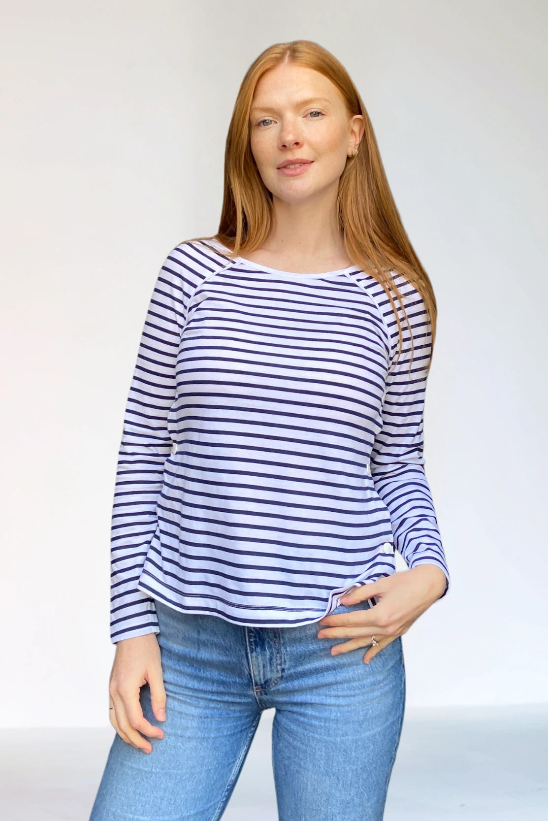 New mother in white with navy stripes organic cotton top for breastfeeding with easy side-openings - capsule wardrobe essential for postpartum style in autumn winter