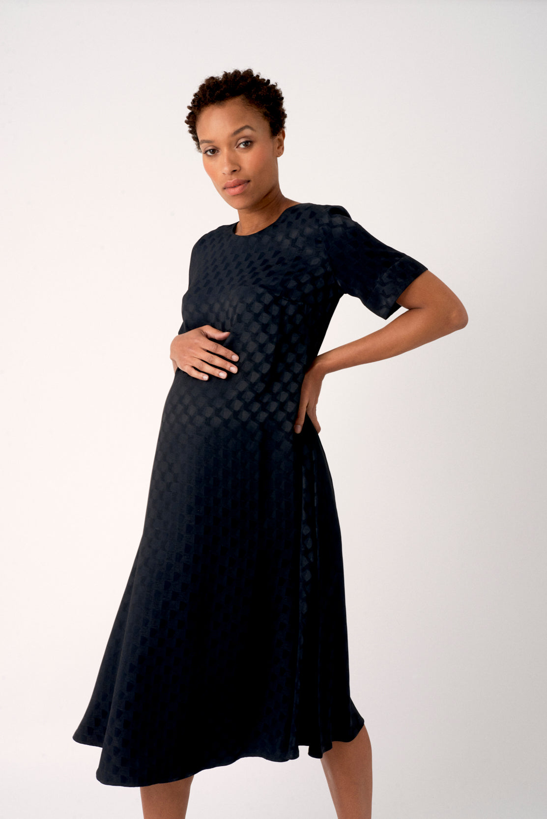 Black trapeze maternity dress. A-line trapeze style maternity dress, designed to be flattering for all stages of pregnancy and post-pregnancy too. Made in a beautiful luxurious textured satin, this is the perfect maternity dress for everyday, occasions or the office.