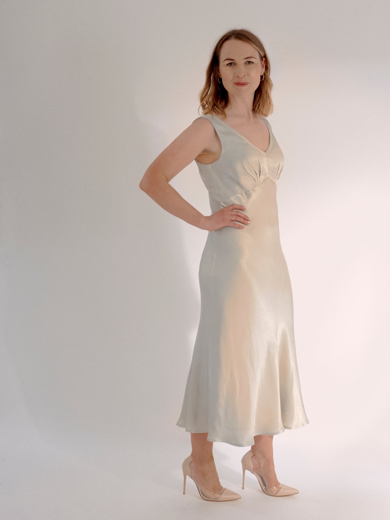 Occasion maternity dress. Make a fashion statement in this stunning silver satin dress. The perfect elevated maternity occasion wear dress for weddings, parties and evening events. The maternity dress’s clever design accommodates a 9-month bump, but is also a very flattering post-pregnancy as it drapes over the body.